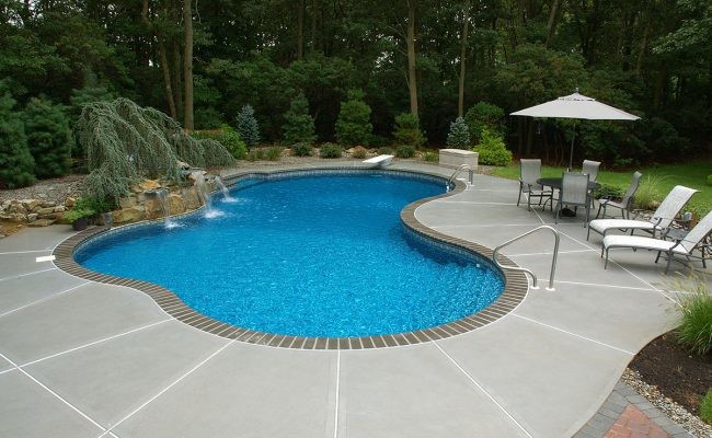 Esempio di una piscina monocorsia chic personalizzata di medie dimensioni e dietro casa con fontane e pavimentazioni in mattoni
