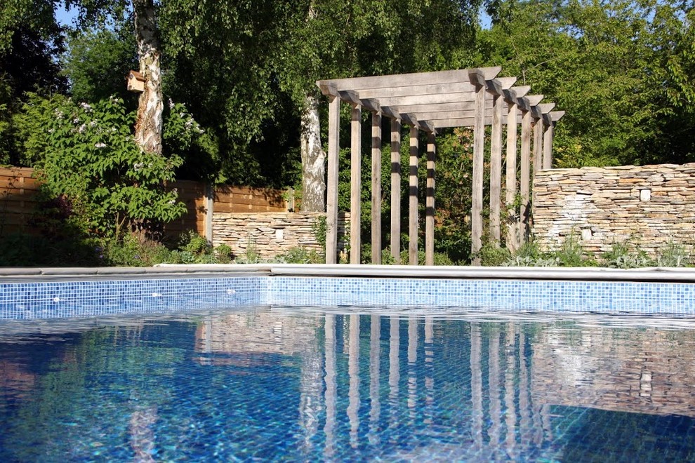 Ispirazione per una piscina contemporanea di medie dimensioni e dietro casa con fontane e pavimentazioni in pietra naturale