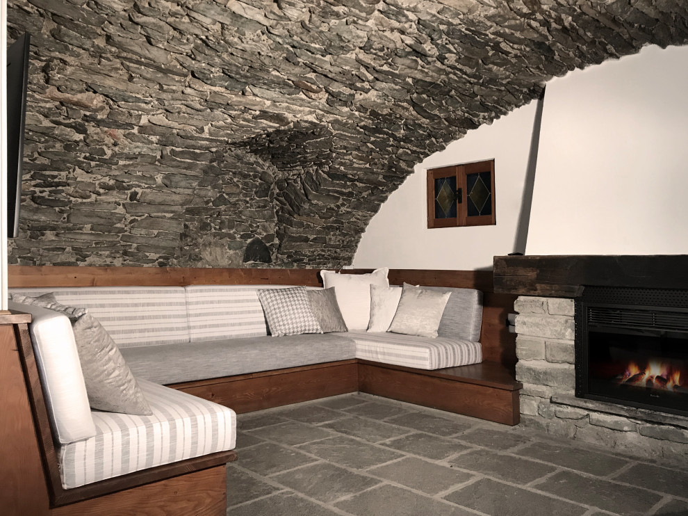 Esempio di una grande taverna rustica con sbocco, pareti bianche, pavimento in pietra calcarea, camino classico, cornice del camino in pietra e pavimento grigio