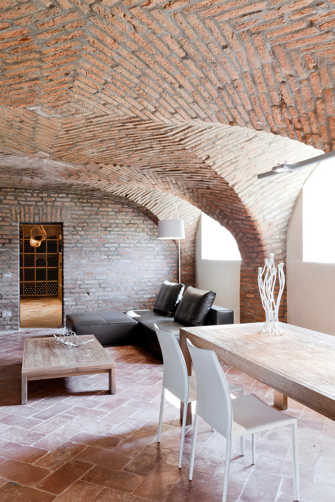 Design ideas for a large mediterranean look-out basement in Milan with brick flooring.