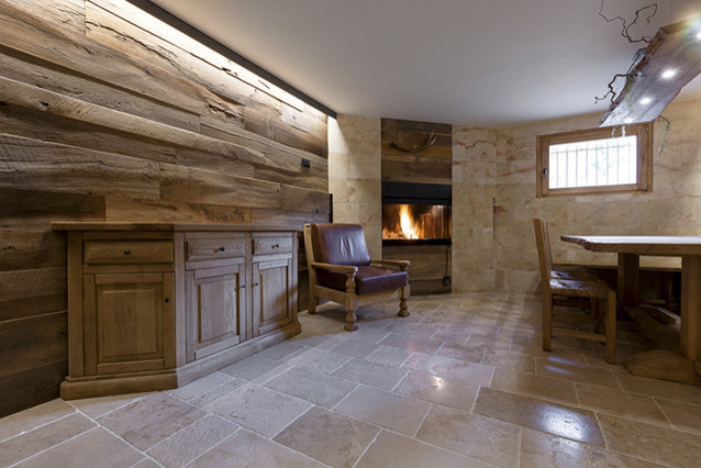 Diseño de sótano con puerta minimalista grande con paredes marrones, suelo de piedra caliza, chimenea de esquina, marco de chimenea de madera y suelo beige