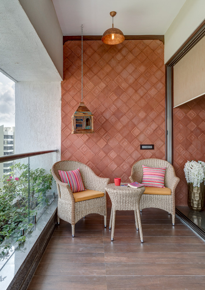 Réalisation d'un balcon asiatique d'appartement avec une extension de toiture et un garde-corps en verre.