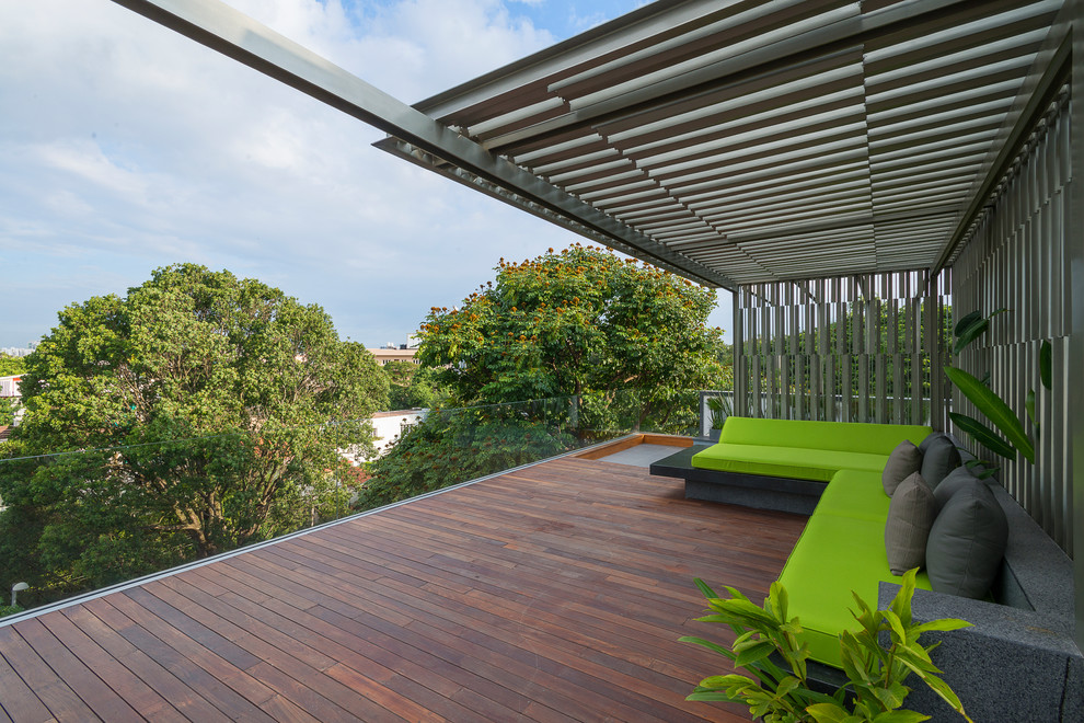 Idée de décoration pour une terrasse sur le toit design avec un garde-corps en verre et une pergola.