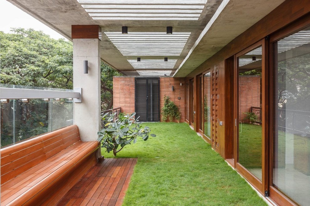 Inspiration pour un balcon minimaliste avec une extension de toiture et un garde-corps en matériaux mixtes.