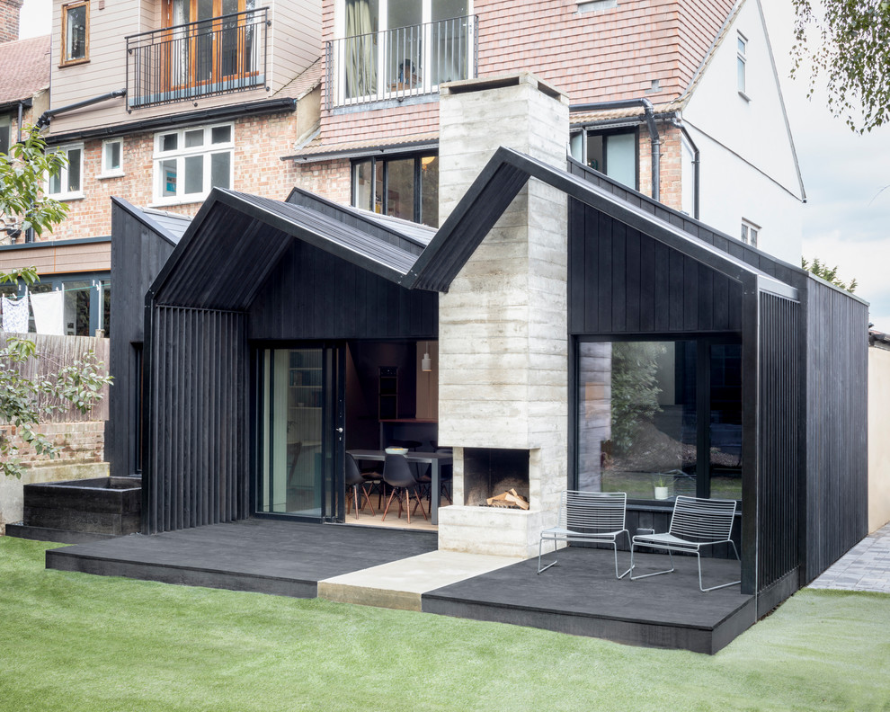 Idee per una terrazza moderna di medie dimensioni e dietro casa con un caminetto e una pergola