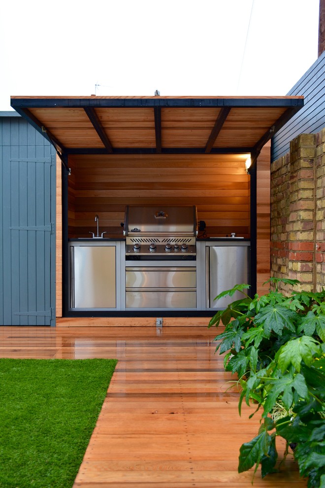 This is an example of a medium sized contemporary back terrace in London with a bbq area.