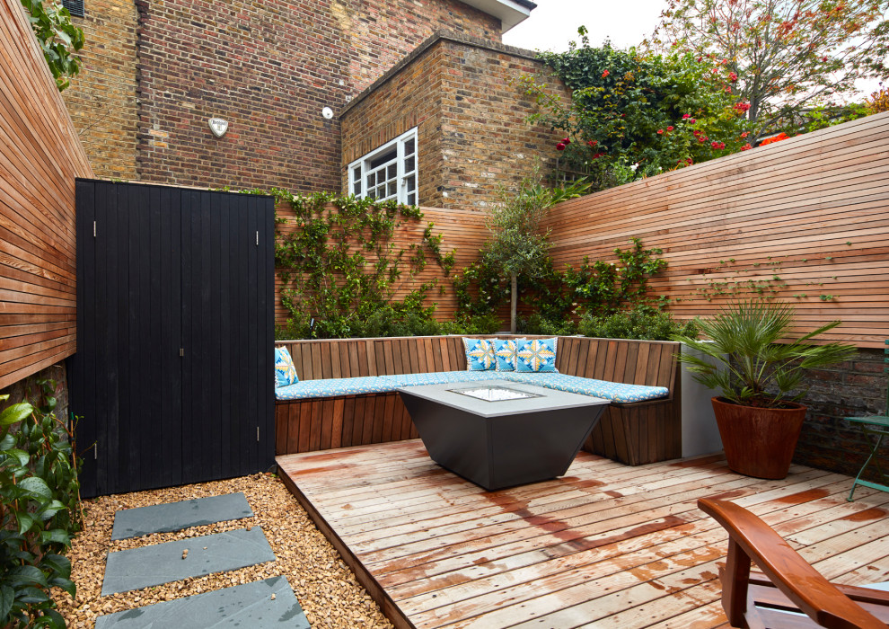 Mid-sized minimalist backyard outdoor kitchen deck photo in London with no cover