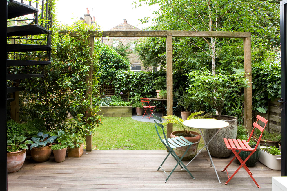 На фото: терраса на заднем дворе в современном стиле с растениями в контейнерах без защиты от солнца с