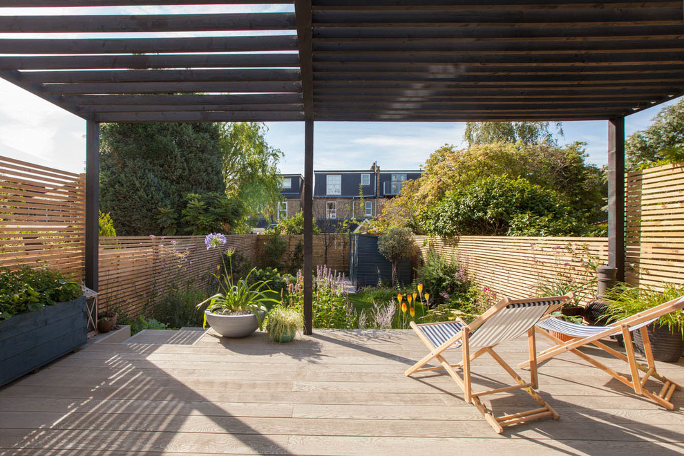 Diseño de terraza contemporánea de tamaño medio en patio trasero con pérgola