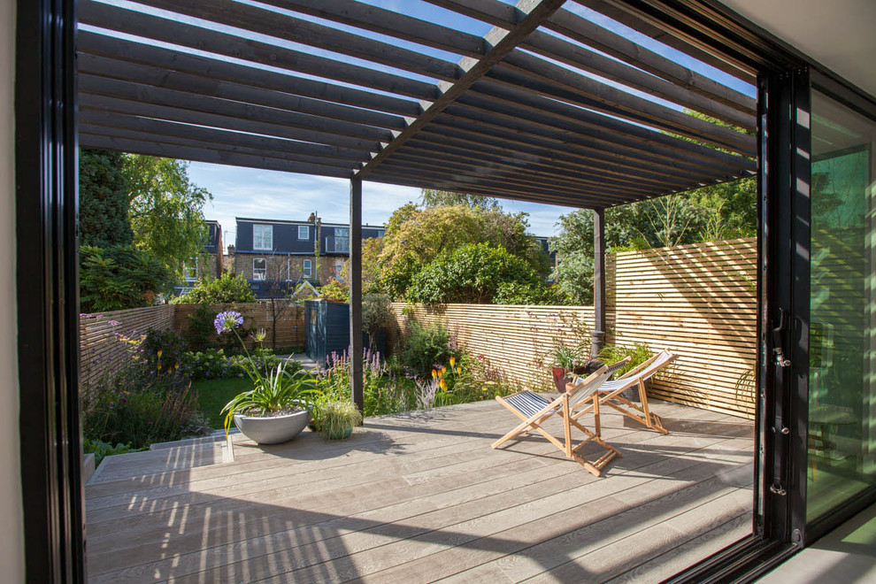Deck - mid-sized contemporary backyard deck idea in Hampshire with a pergola