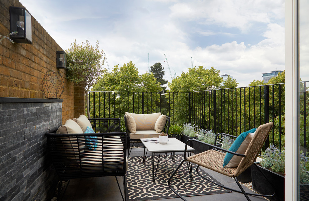 Small eclectic side terrace in London with no cover and a potted garden.