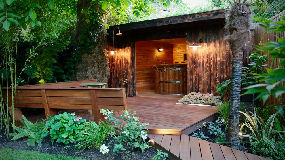 Example of a large island style backyard outdoor shower deck design in London