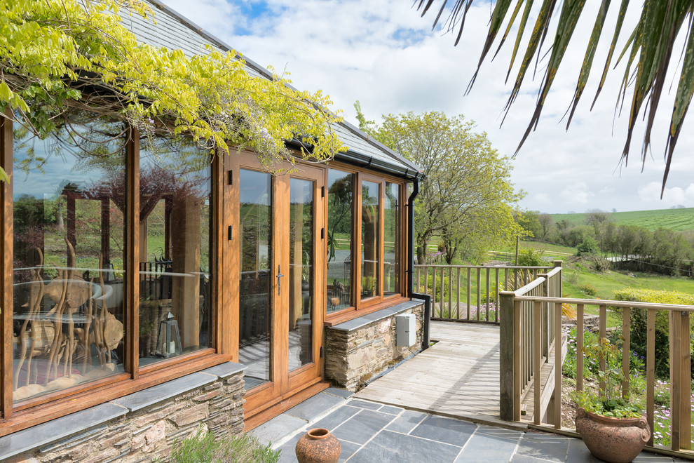 Photo of a large country back terrace in Devon with a pergola.