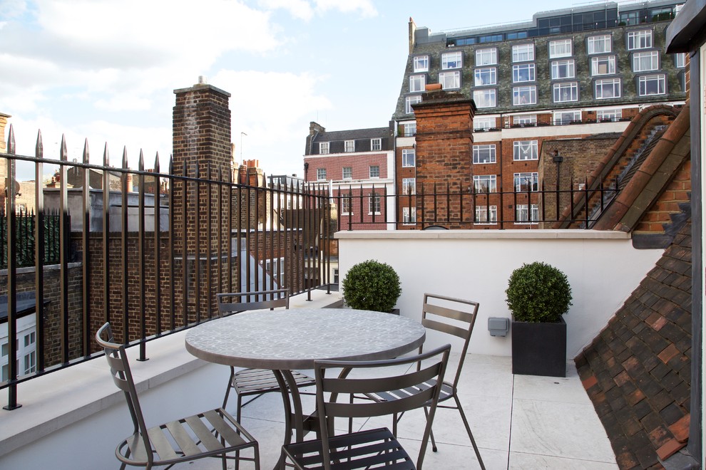 This is an example of a medium sized contemporary side terrace in London with a potted garden and no cover.