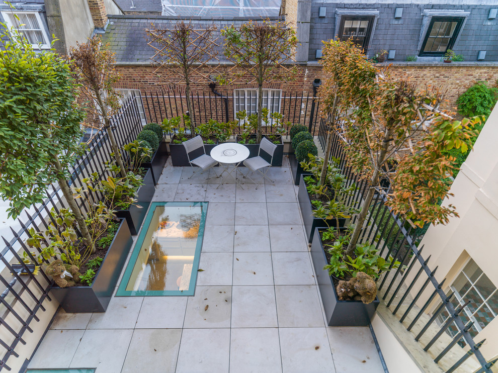 Inspiration for a mid-sized contemporary rooftop deck container garden remodel in London with no cover