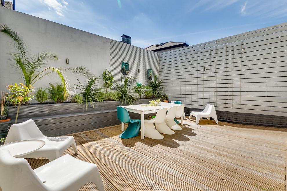 Ejemplo de terraza clásica renovada de tamaño medio en patio trasero con jardín de macetas