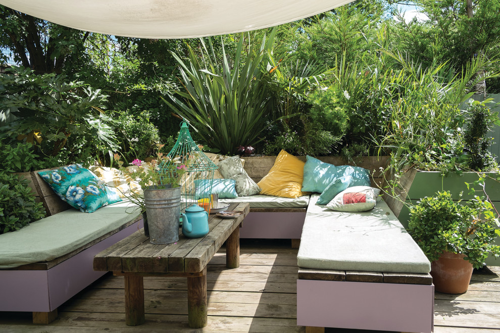 Eclectic backyard deck container garden photo in Dorset with an awning
