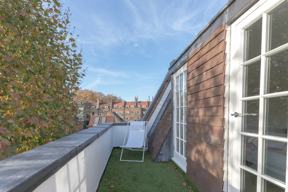 Imagen de terraza minimalista pequeña sin cubierta en azotea con privacidad y barandilla de varios materiales