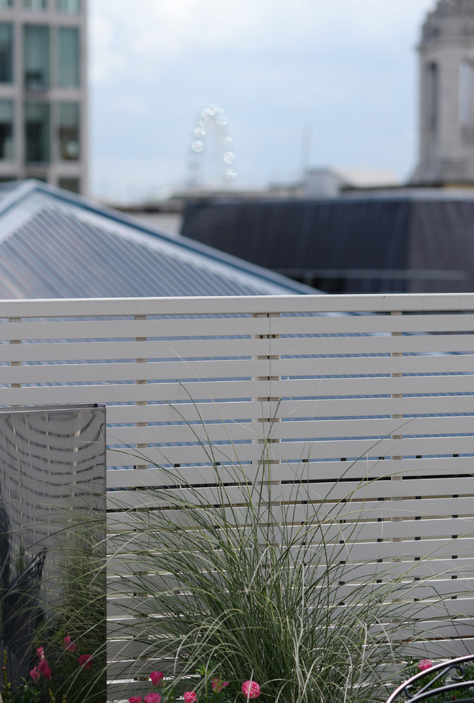 This is an example of a medium sized contemporary roof terrace in London with a potted garden and no cover.