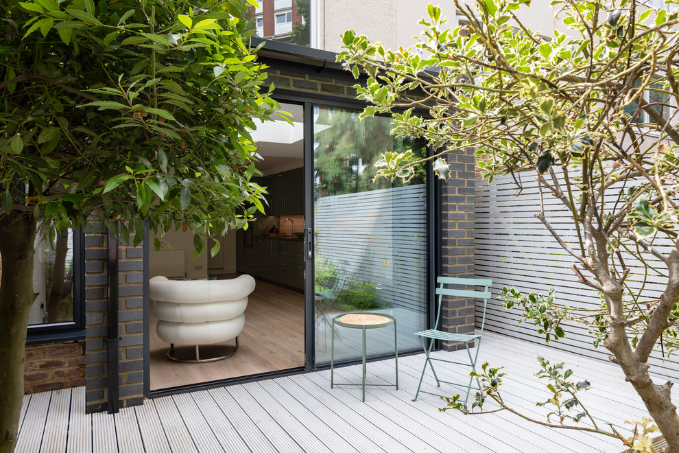 Стильный дизайн: терраса на заднем дворе в современном стиле с забором без защиты от солнца - последний тренд