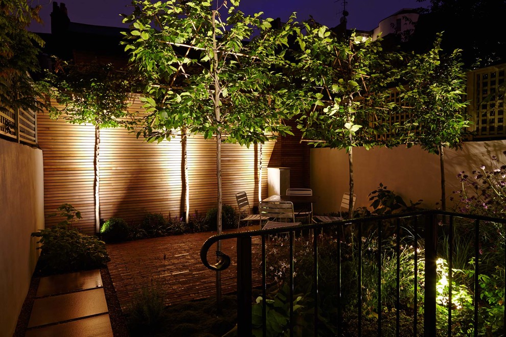На фото: терраса среднего размера на заднем дворе в стиле неоклассика (современная классика) без защиты от солнца с