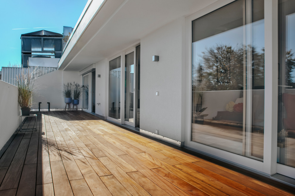Deck - scandinavian deck idea in Munich with a roof extension