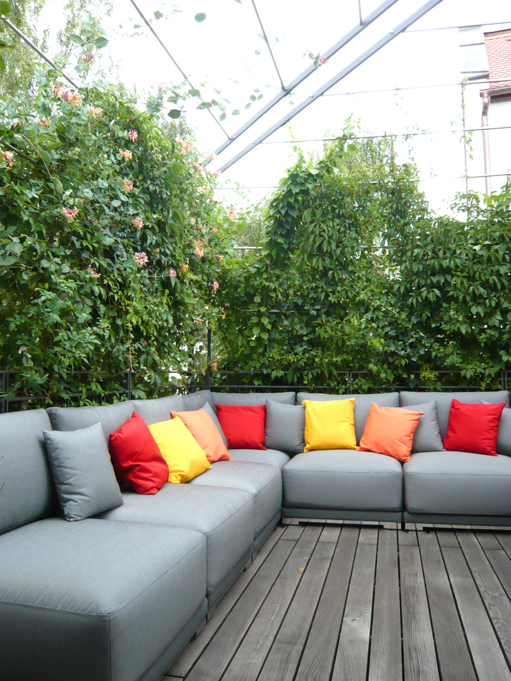 This is an example of a large contemporary roof rooftop terrace in Munich with a living wall and a pergola.