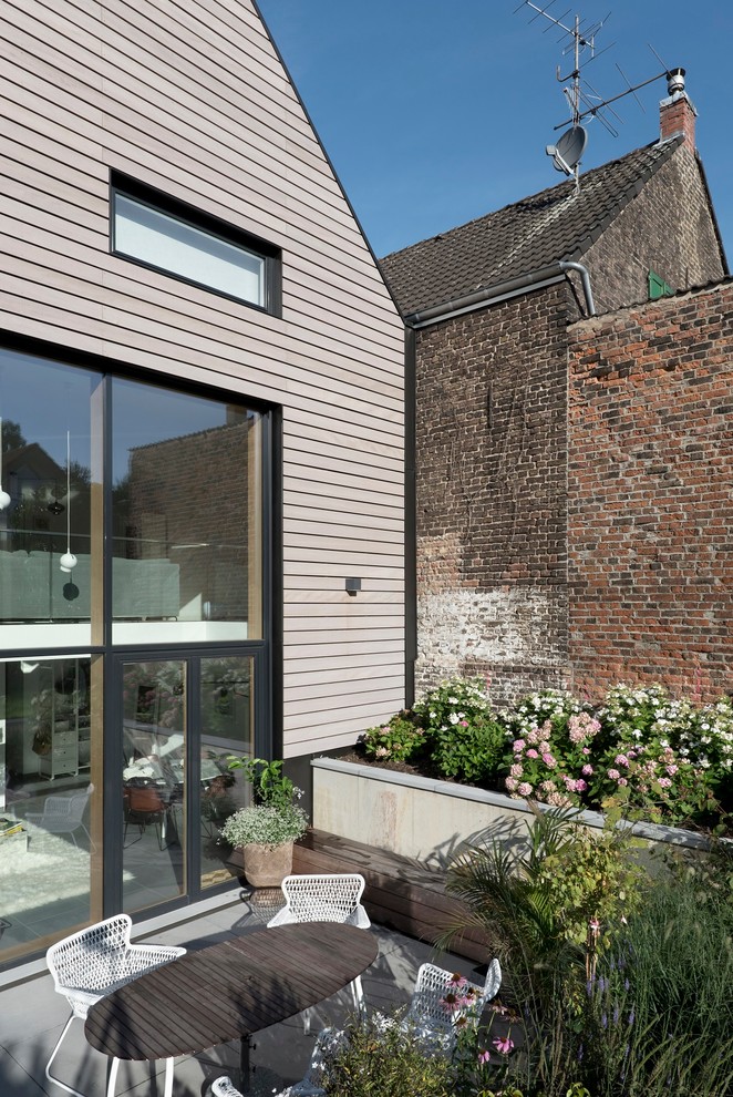 Inspiration för små lantliga terrasser på baksidan av huset, med en vertikal trädgård och takförlängning