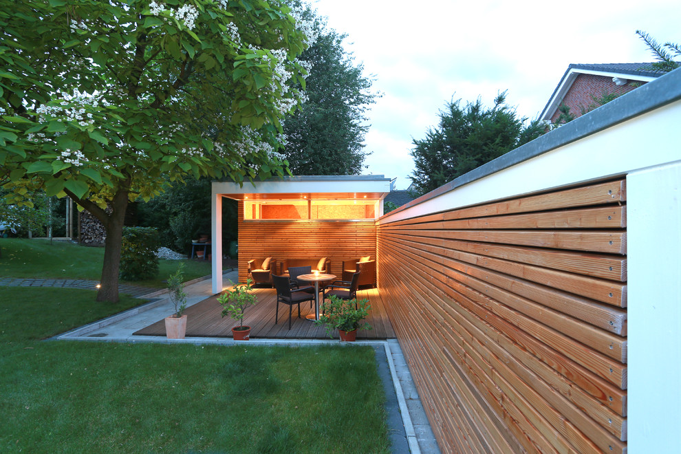 Идея дизайна: терраса среднего размера на заднем дворе в современном стиле с растениями в контейнерах и навесом