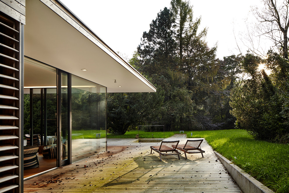 Cette photo montre une terrasse latérale moderne de taille moyenne avec une extension de toiture.