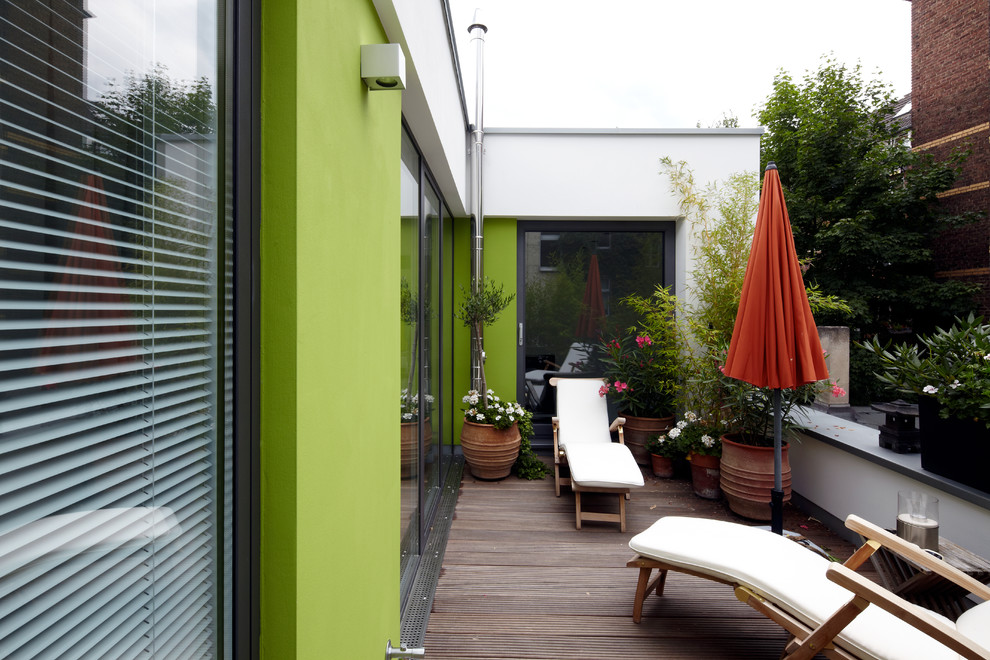 Пример оригинального дизайна: терраса среднего размера на заднем дворе в современном стиле с растениями в контейнерах без защиты от солнца