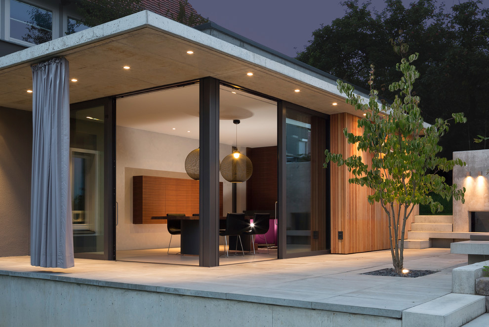 Diseño de terraza contemporánea de tamaño medio sin cubierta en patio trasero con iluminación