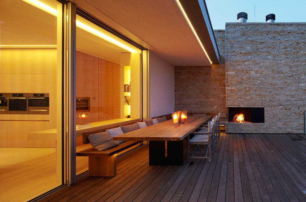 Photo of a large scandi back terrace in Munich with a fire feature and a roof extension.