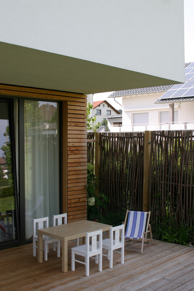Aménagement d'une terrasse avec des plantes en pots contemporaine de taille moyenne avec une extension de toiture.