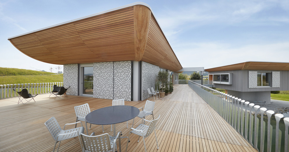 Idee per una grande terrazza design sul tetto e sul tetto con un giardino in vaso e un tetto a sbalzo