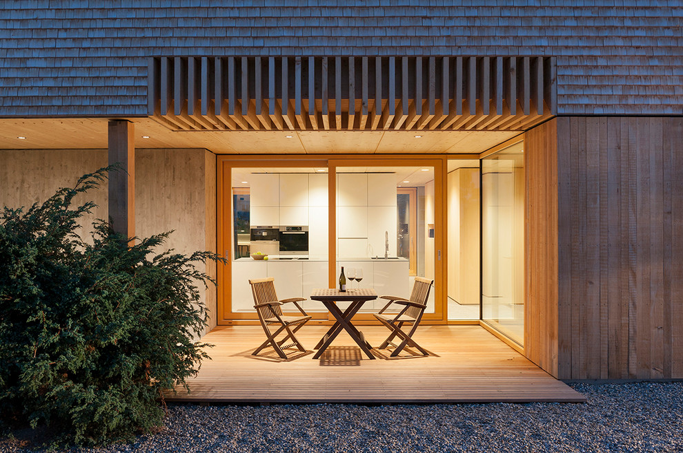 Idée de décoration pour une terrasse latérale design de taille moyenne avec une extension de toiture.