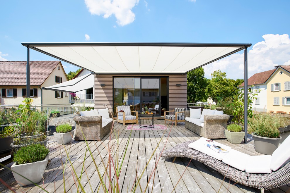 Idee per una terrazza country di medie dimensioni e dietro casa con un giardino in vaso e un parasole