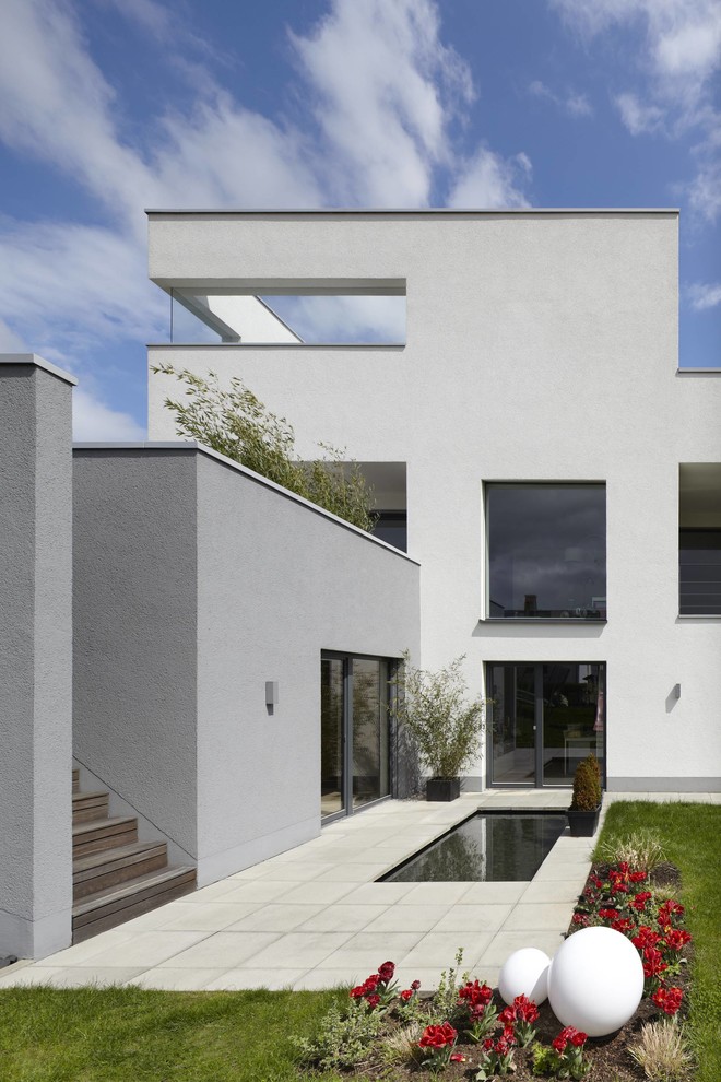 Große, Unbedeckte Moderne Terrasse hinter dem Haus mit Wasserspiel in Sonstige