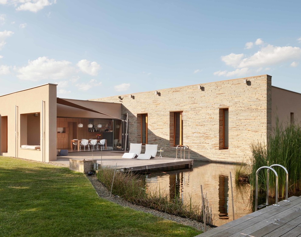 Inspiration för mellanstora moderna terrasser längs med huset, med utekök och markiser