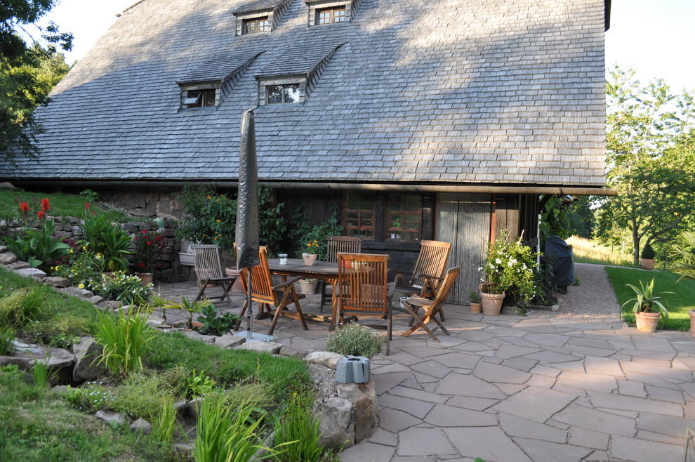 This is an example of a large rural back terrace in Other with a potted garden and no cover.