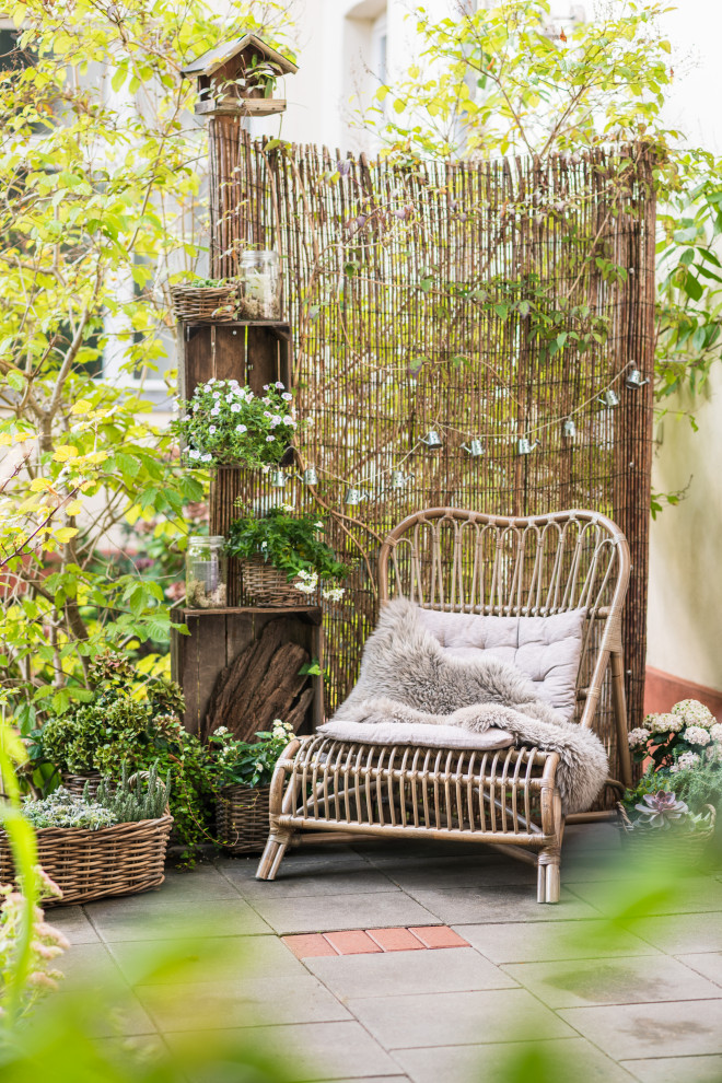 На фото: маленькая терраса на боковом дворе в скандинавском стиле с перегородкой для приватности и деревянными перилами для на участке и в саду