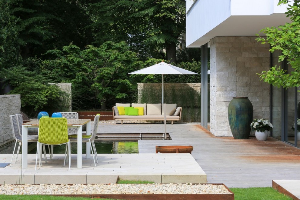 Diseño de terraza actual grande sin cubierta en patio trasero con brasero