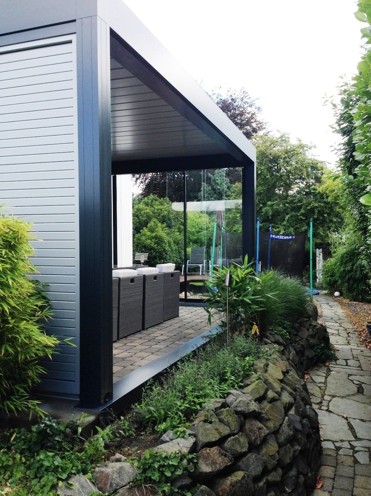 This is an example of a medium sized contemporary terrace in Essen with a roof extension.