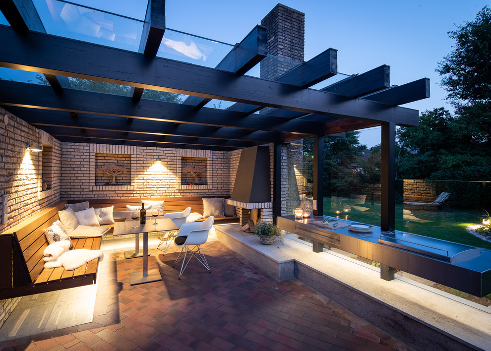 Photo of a medium sized contemporary back terrace in Bremen with an outdoor kitchen and a pergola.