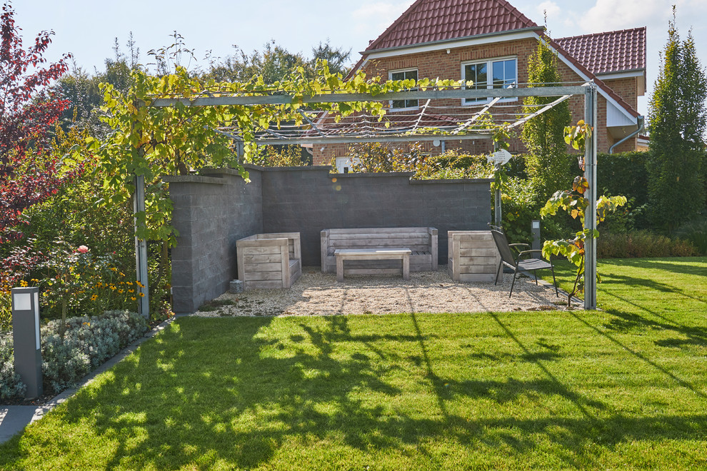 Foto di una terrazza design di medie dimensioni e nel cortile laterale con una pergola e un focolare