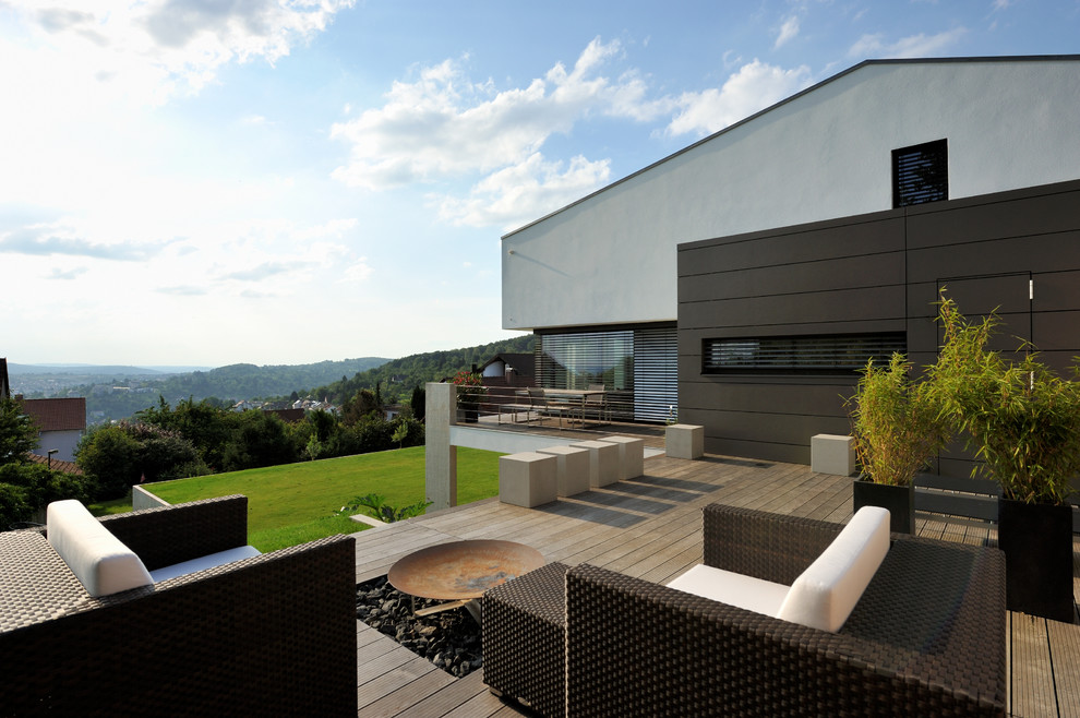 Inspiration for a large contemporary side yard deck remodel in Stuttgart with a fire pit and no cover