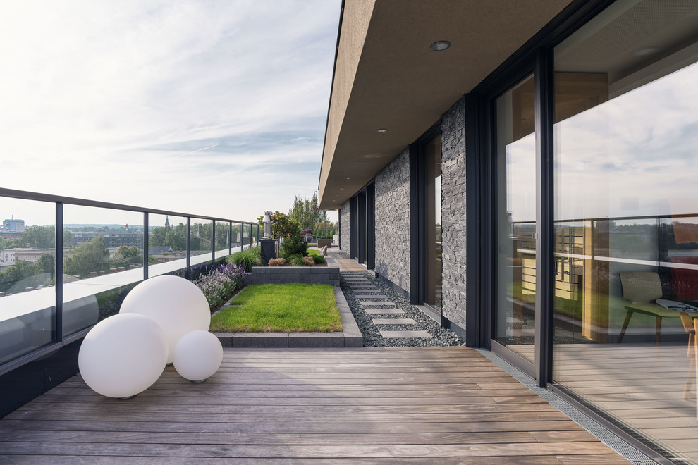 Inspiration för stora moderna terrasser, med utekrukor och räcke i glas