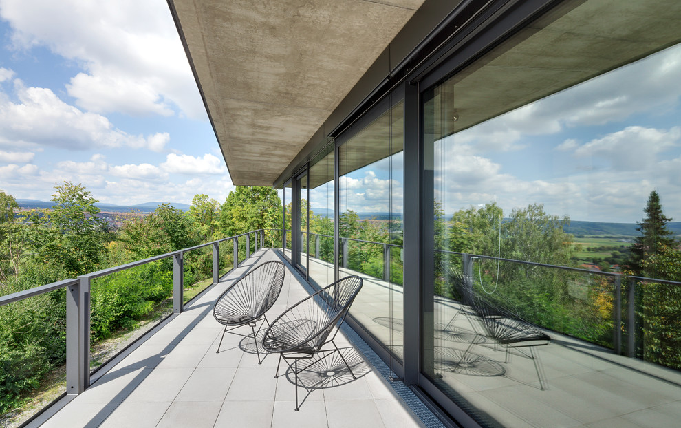 Ispirazione per un balcone moderno di medie dimensioni con un tetto a sbalzo