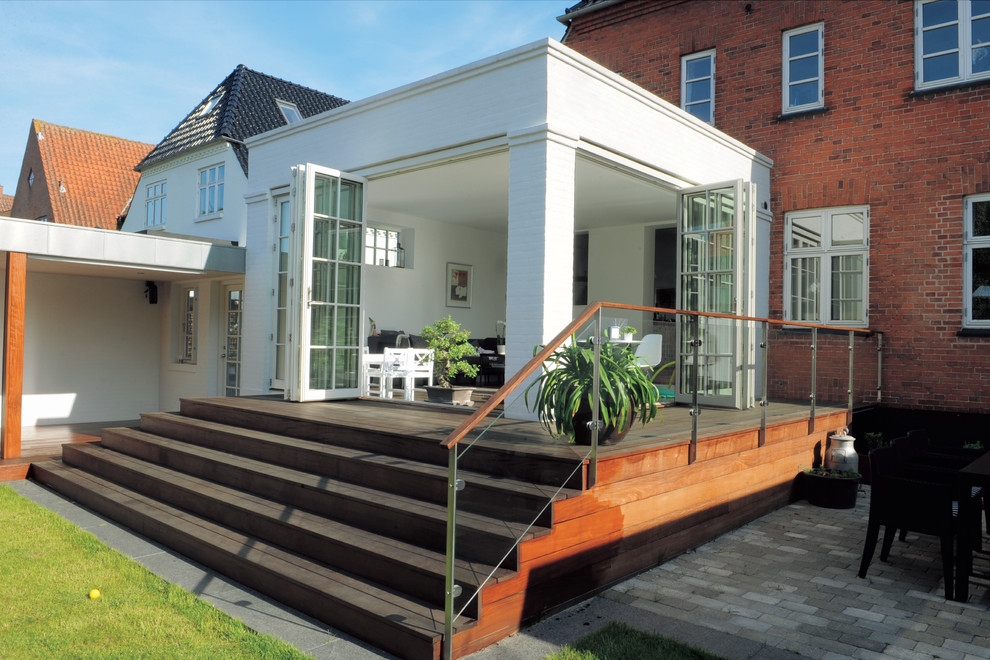 This is an example of a medium sized traditional back terrace in Odense with a roof extension and all types of cover.