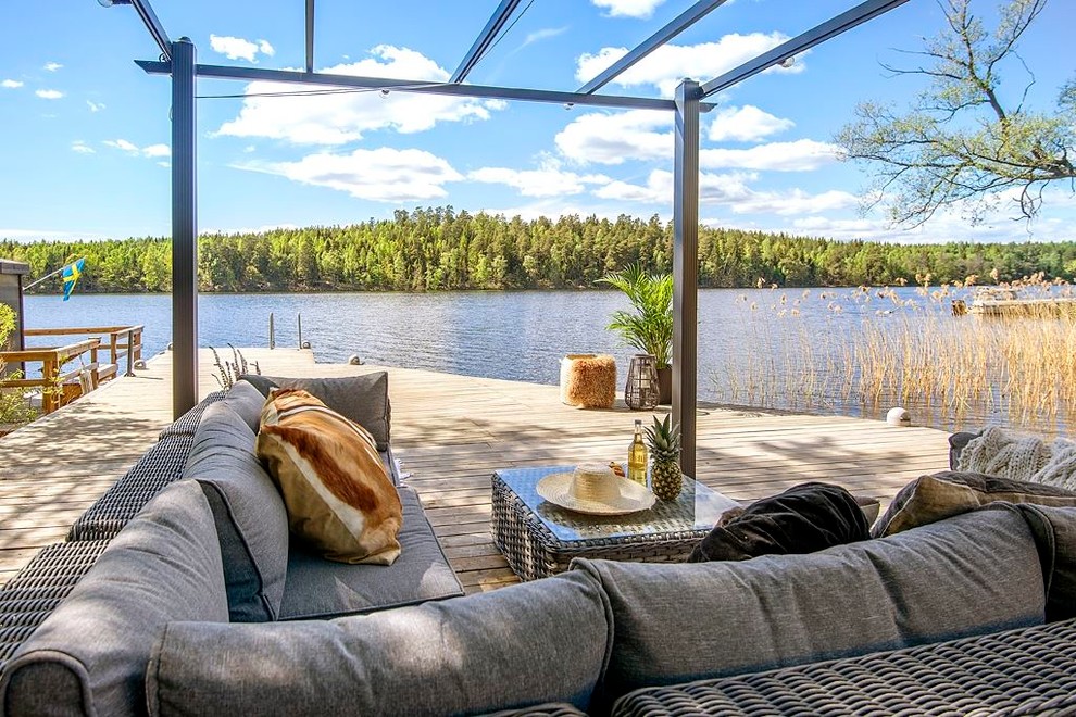 This is an example of a scandi back terrace in Stockholm with a pergola and a dock.